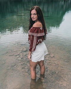 woman wearing red off-shoulder and white short shorts standing thumbnail