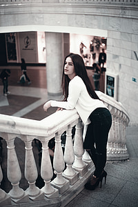 woman wearing white long-sleeved shirt standing on staircas thumbnail