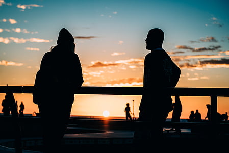 silhouette of two men standing during sunset thumbnail