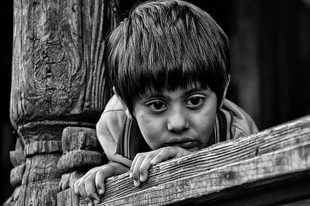 boy holding on brown wooden plank in black in white photography thumbnail