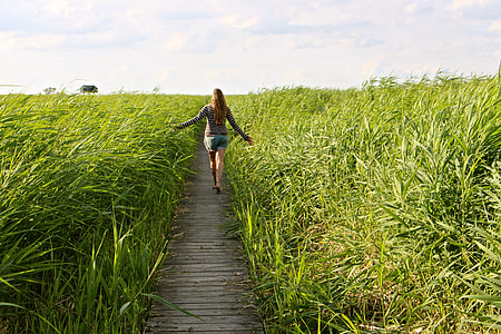 woman walking near grass field thumbnail