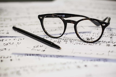 black framed eyeglasses near black ballpoint pen on top of white printer paper thumbnail