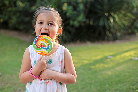 toddler's licking multicolored lollipop thumbnail
