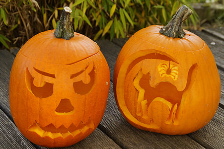 two Jack-O-Lanterns on brown wooden surface near green grass thumbnail