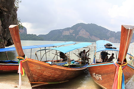 brown boats near rock formation thumbnail