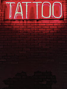lighted tattoo signage on brick wall thumbnail