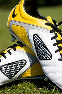 pair of white-and-yellow Nike cleats thumbnail