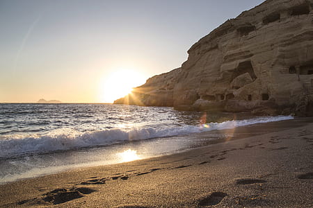 photo of seashore near mountain during daytime thumbnail