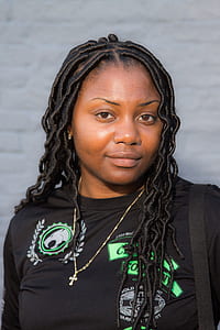 woman wearing black shirt with gold-colored necklace thumbnail