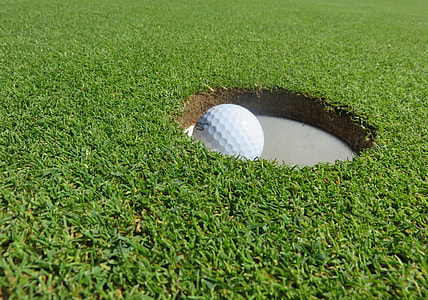white golf ball on hole during daytime thumbnail