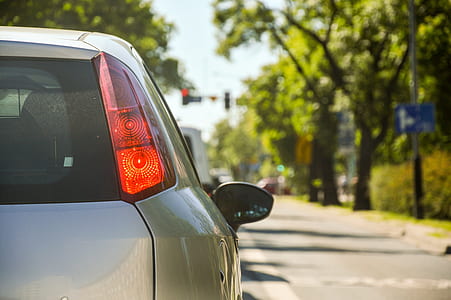 silver vehicle on road with taillight turned on at daytime thumbnail