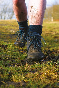 man wearing black leather boots standing on mud at daytime thumbnail