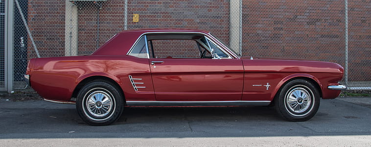 red Ford Mustang coupe parked near brick wall thumbnail