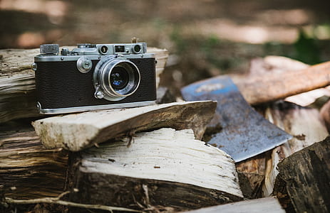 selective focus photography of black DSLR camera on firewoods thumbnail