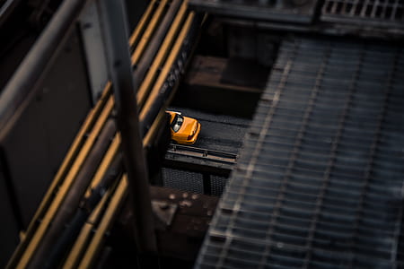 selective focus photography of yellow sedan on road thumbnail
