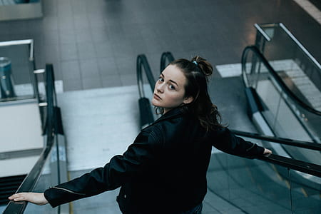 shallow focus photography of woman standing on escalator thumbnail