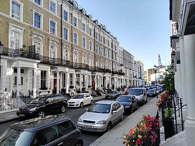 vehicles parked between concrete buildings under blue sky thumbnail