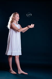 girl standing while catching bubble thumbnail