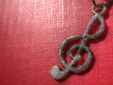 close-up photo of silver-colored G-clef pendant thumbnail