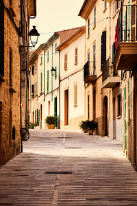 narrow road surrounded with concrete houses under white sky thumbnail