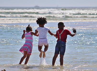 three kids playing on shore during daytime thumbnail