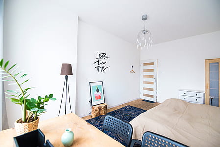 rectangular brown wooden dining table near brown bed thumbnail