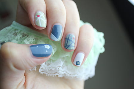 woman showing blue, white, and green nail manicure thumbnail