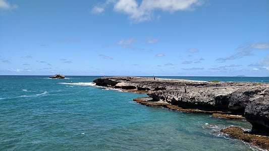 man standing on cliff beside body of water thumbnail