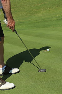 person holding golf putter on golf field at daytime thumbnail