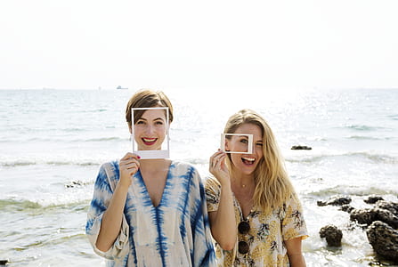 two woman holding white frames thumbnail