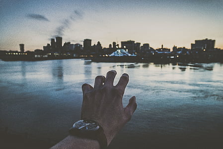 person raising left arm in front of body of water thumbnail