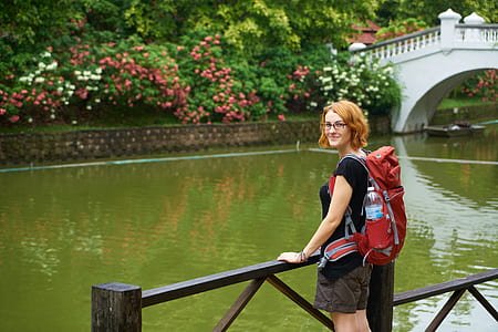 woman standing beside railing near body of water thumbnail