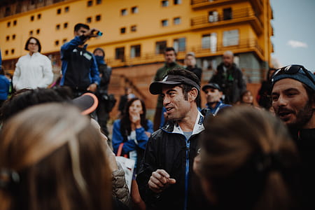 man wearing cap and crowd gathering thumbnail