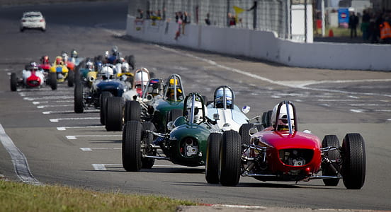 selective focus photography of racers on track during daytime thumbnail