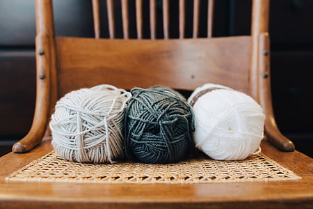 two white and one black ball yarns on chair thumbnail