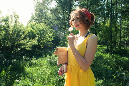 woman in yellow sleeveless dress near forest during daytime thumbnail