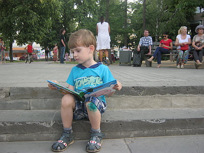 boy sitting on stairs while reading book thumbnail