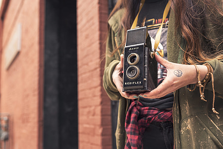 woman wearing green zip-up hoodie holding Rediflex camera thumbnail