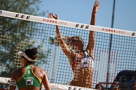 women playing volleyball during daytime thumbnail