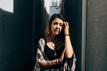 woman in black tank top and multicolored cardigan standing beside of wall during daytime thumbnail