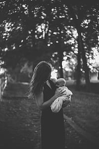 grayscale photo of woman carrying child thumbnail