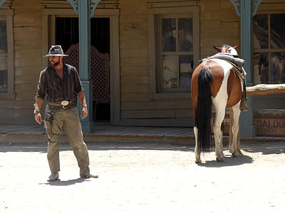 man standing beside horse thumbnail