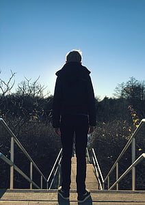 boy standing on stairs during daytime thumbnail