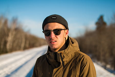 shallow focus photography of man wearing brown jacket and black sunglasses thumbnail
