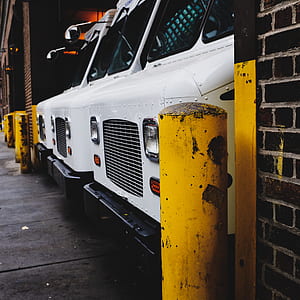 several white trucks parked inside garage thumbnail