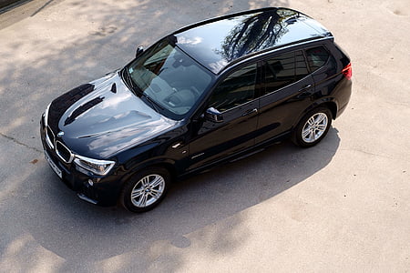 black BMW X1 SUV parked on concrete pavement thumbnail
