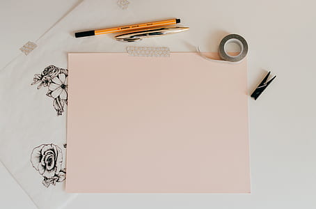 pink paper beside orange and brown pens thumbnail
