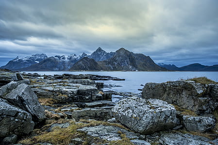 body of water surrounded with mountains thumbnail