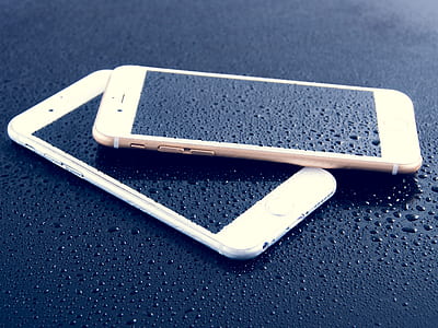 two assorted-color iPhones on black surface thumbnail