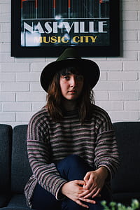 woman in black and gray striped sweater and wearing green fedora thumbnail